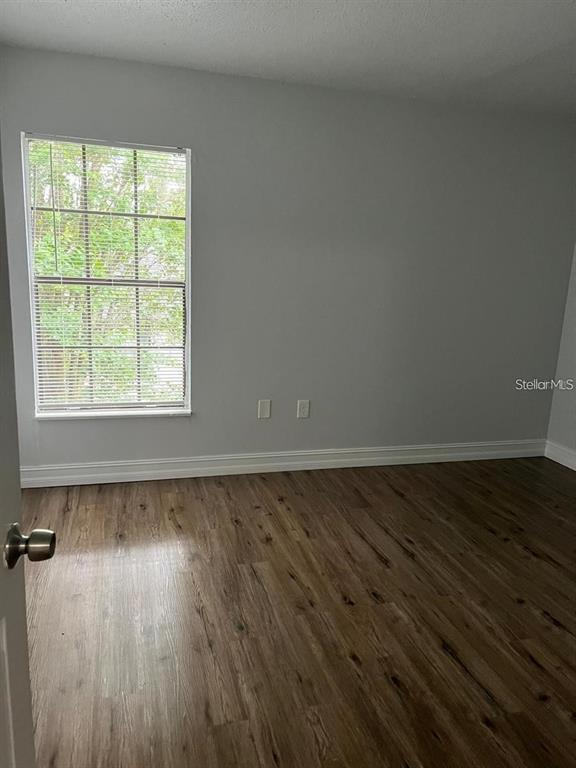 1805 Crystal Grove Drive, Unit 1809 Lakeland, FL 33801 - Photo 7 of 7 a view of an empty room with wooden floor and a window