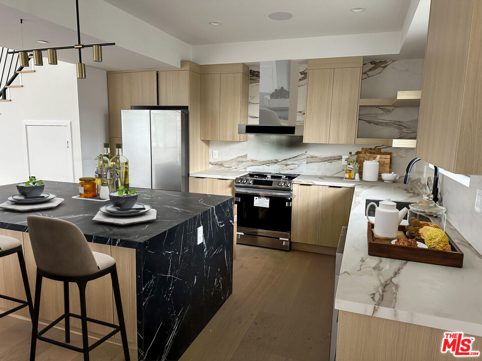 a kitchen with stainless steel appliances granite countertop a sink stove and refrigerator