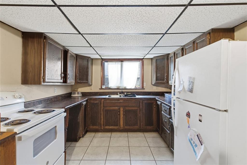1057 Keene Street Springdale, PA 15144 - Photo 18 of 50 a kitchen with stainless steel appliances granite countertop a stove a sink and a refrigerator
