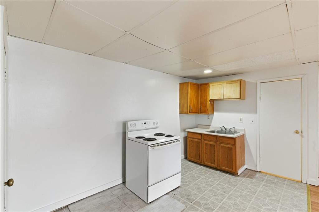 1057 Keene Street Springdale, PA 15144 - Photo 35 of 50 a kitchen with a stove cabinets and a refrigerator