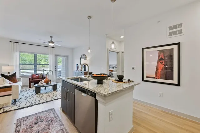 a view of kitchen island a sink a counter space and living room