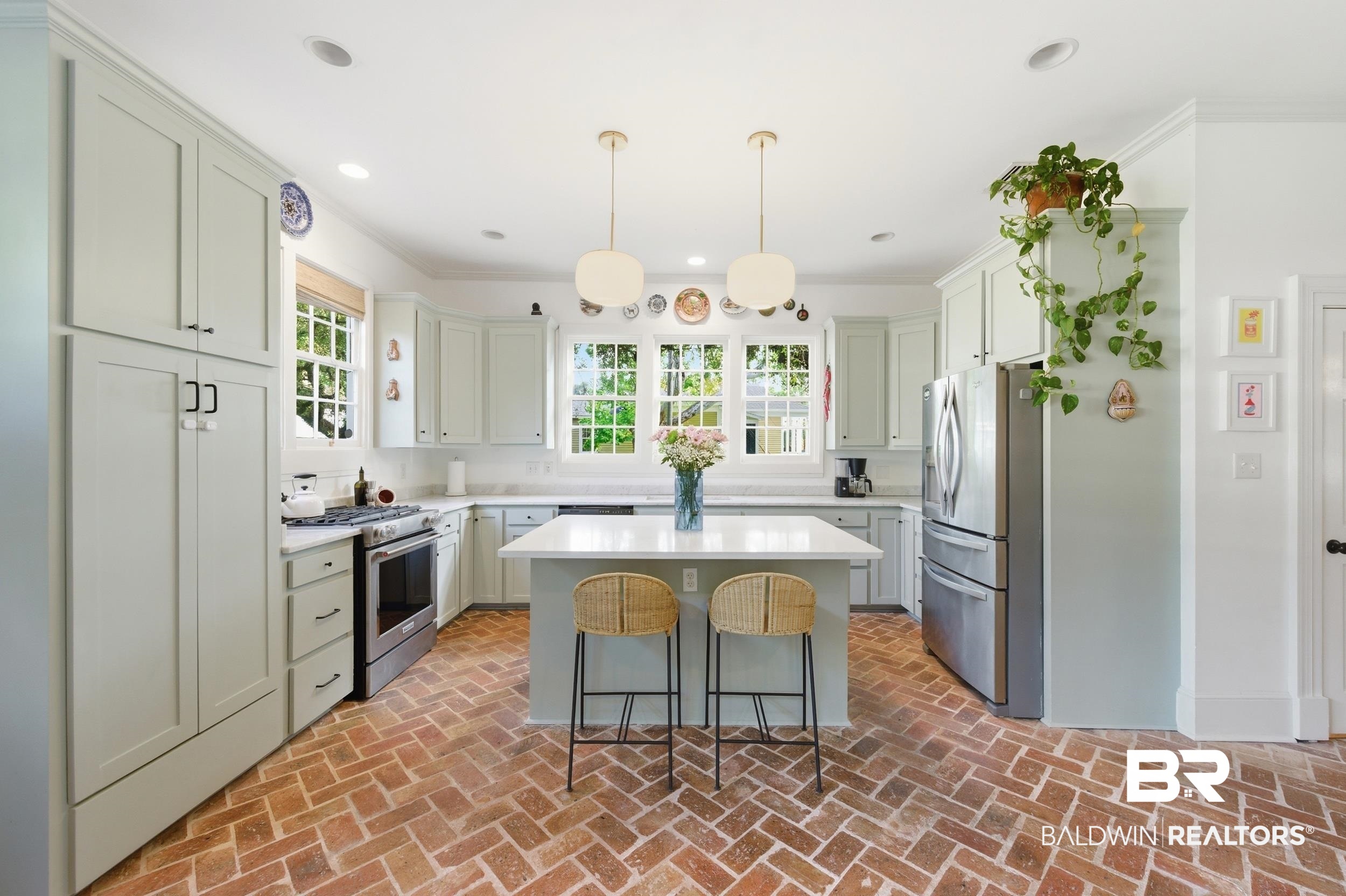 350 Charles Street Mobile, AL 36604 - Photo 8 of 52 Kitchen featuring herringbone brick flooring, light-colored cabinetry, stainless steel appliances, a center island with countertop seating, and recessed lighting
