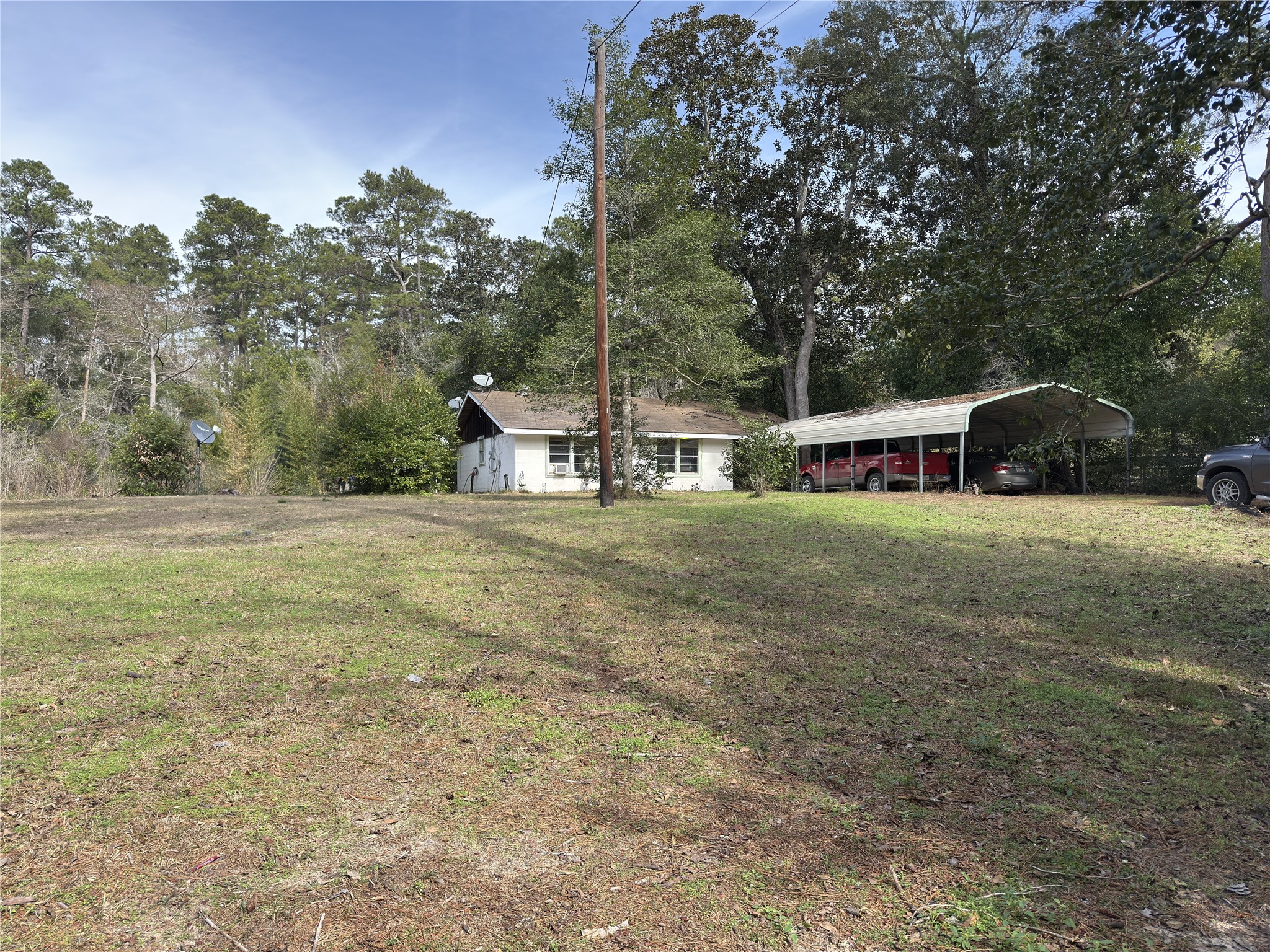 a view of a house with backyard and trees