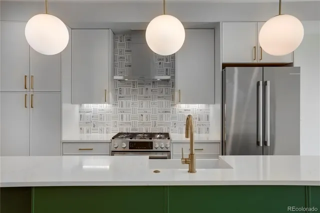 a kitchen with kitchen island a counter and a refrigerator