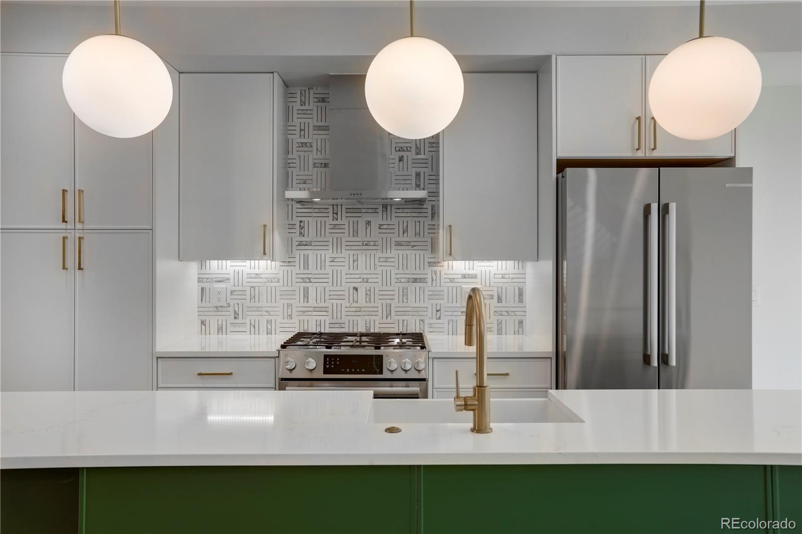 1065-25 25th Street, Unit A Denver, CO 80205 - Photo 11 of 45 a kitchen with kitchen island a counter and a refrigerator