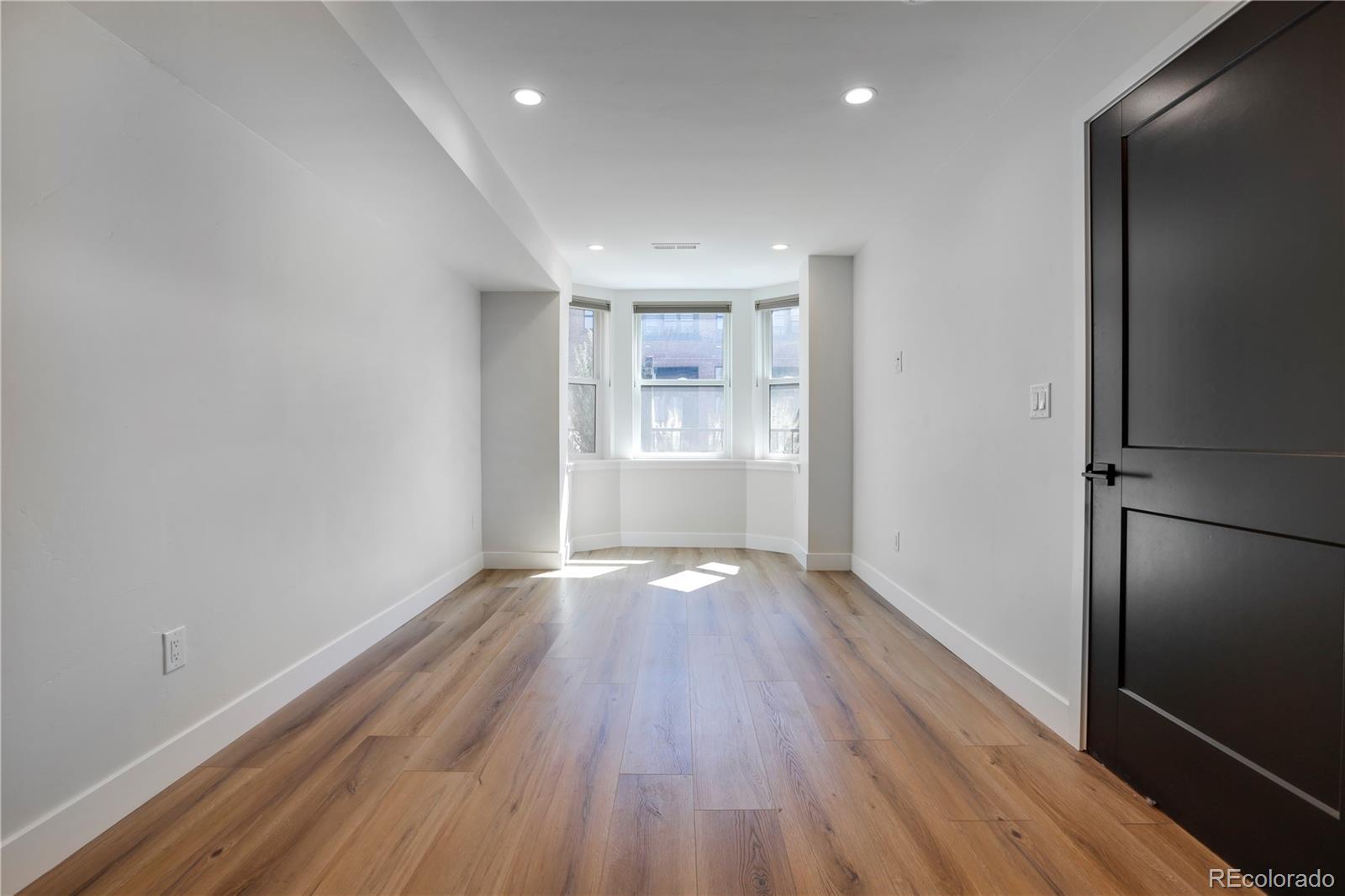1065-25 25th Street, Unit A Denver, CO 80205 - Photo 33 of 45 a view of an empty room with wooden floor and a window