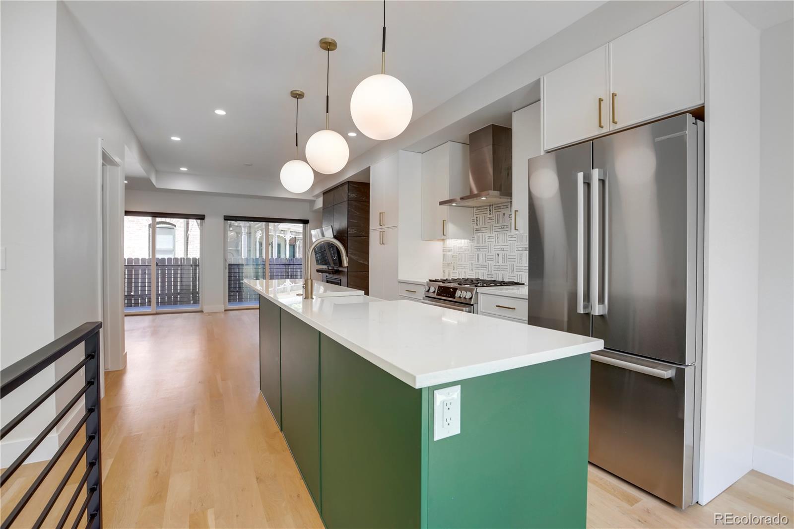 1065-25 25th Street, Unit A Denver, CO 80205 - Photo 4 of 45 a kitchen with kitchen island white cabinets and stainless steel appliances