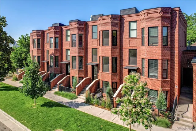 a front view of a residential apartment building with a yard