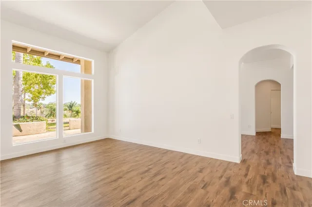 a view of a big room with wooden floor and windows