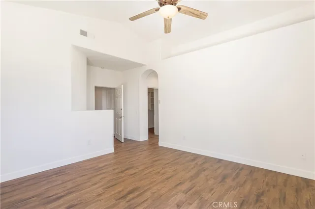 a view of a room with wooden floor and ceiling fan