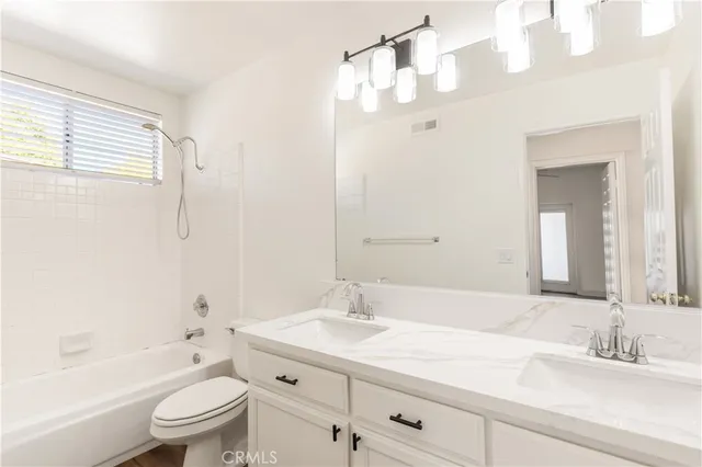 a bathroom with a granite countertop sink a toilet and a bathtub