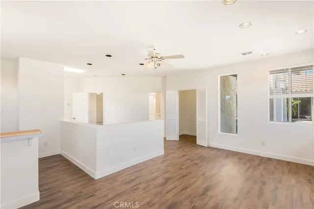 a view of a big room with wooden floor and a kitchen