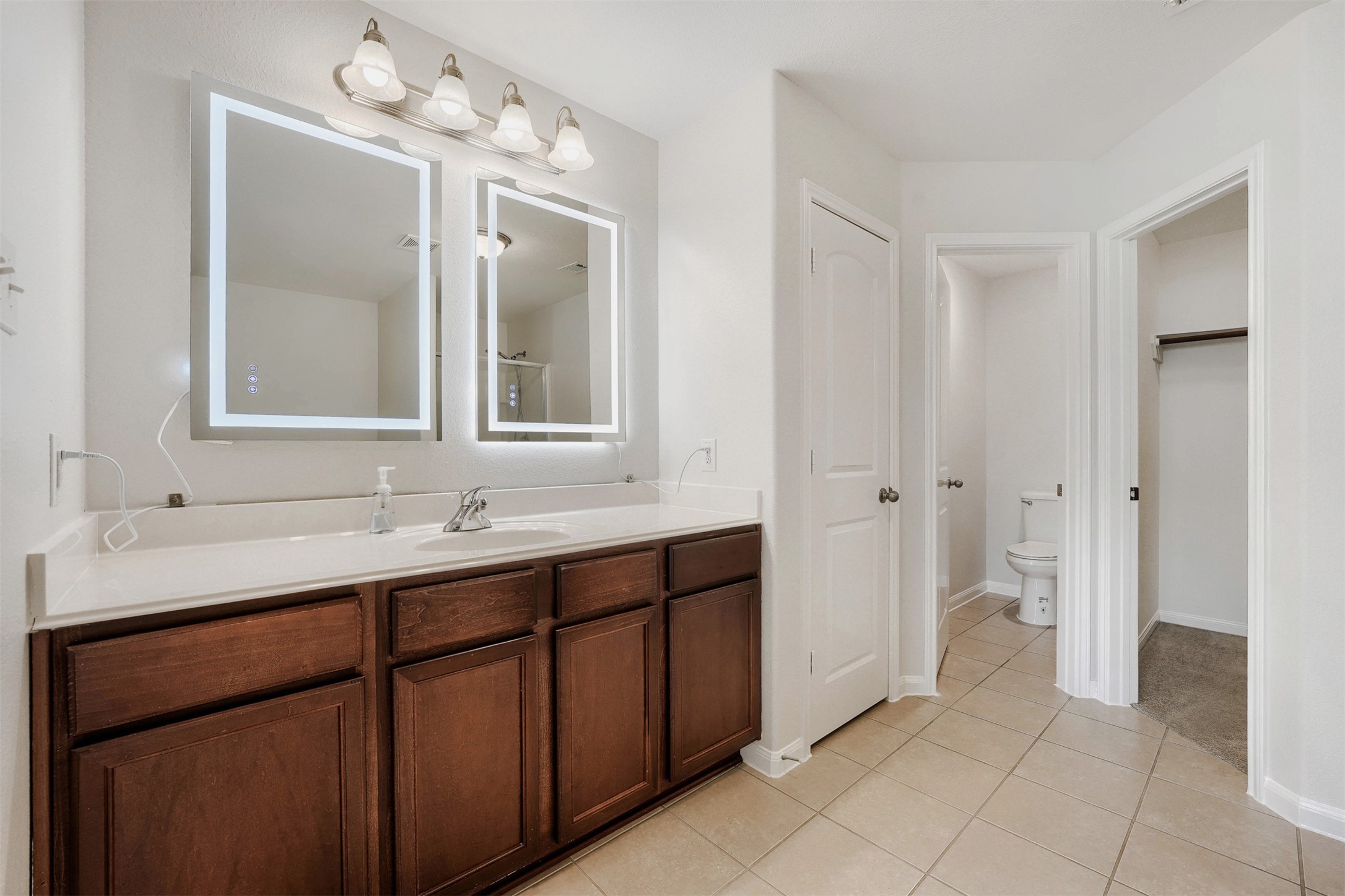 13408 Clara Martin Road Manor, TX 78653 - Photo 17 of 27 a bathroom with a double vanity sink and a mirror