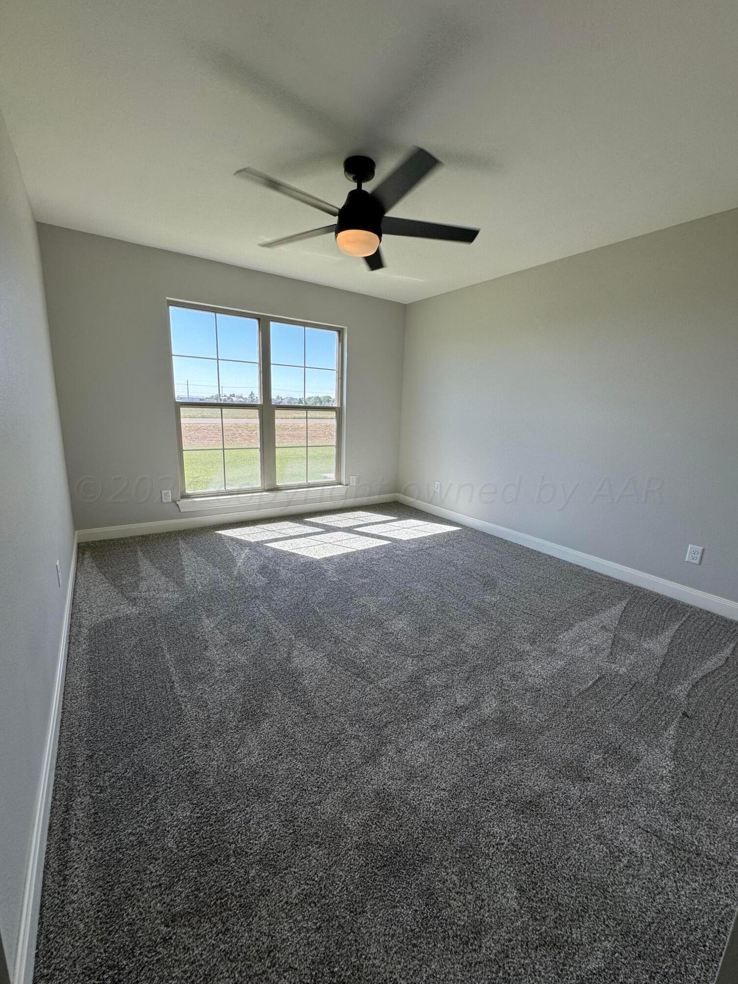 3801 Whitetail Springs Road Amarillo, TX 79119 - Photo 12 of 13 an empty room with ceiling fan and windows