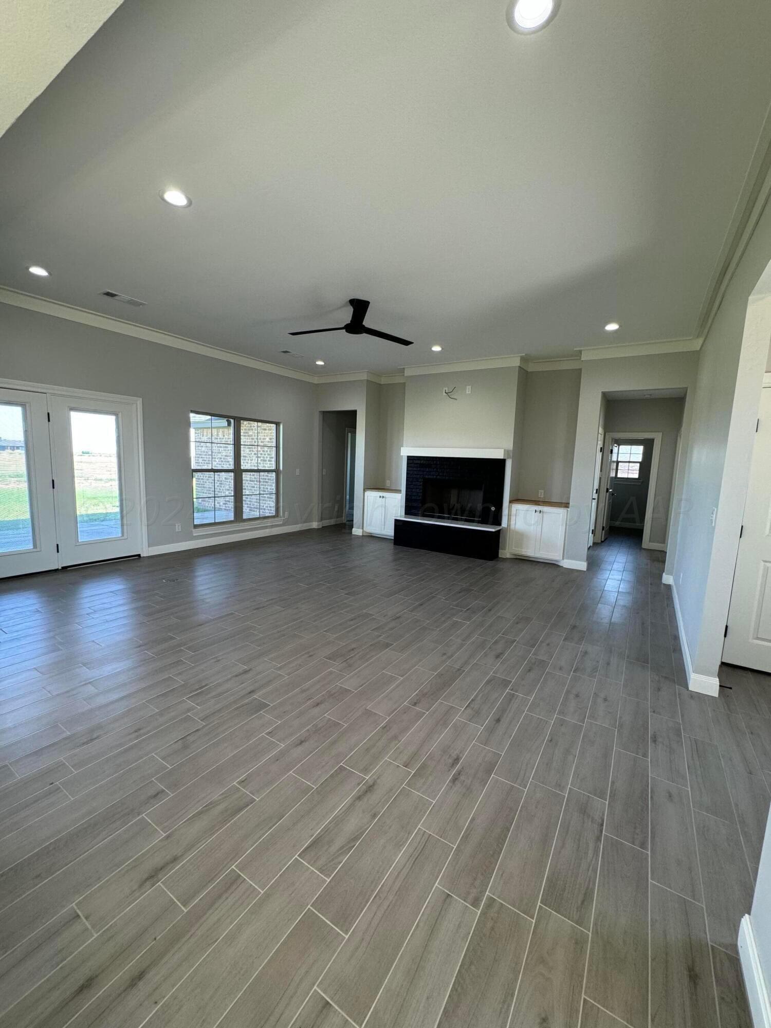 3801 Whitetail Springs Road Amarillo, TX 79119 - Photo 4 of 13 an empty room with wooden floor and windows
