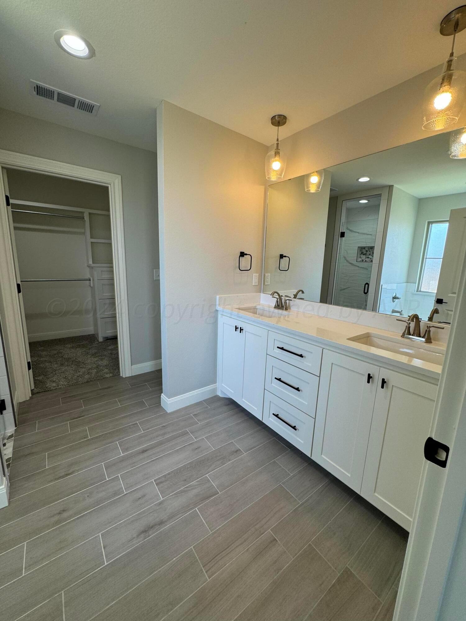 3801 Whitetail Springs Road Amarillo, TX 79119 - Photo 5 of 13 a spacious bathroom with a double vanity sink and a mirror