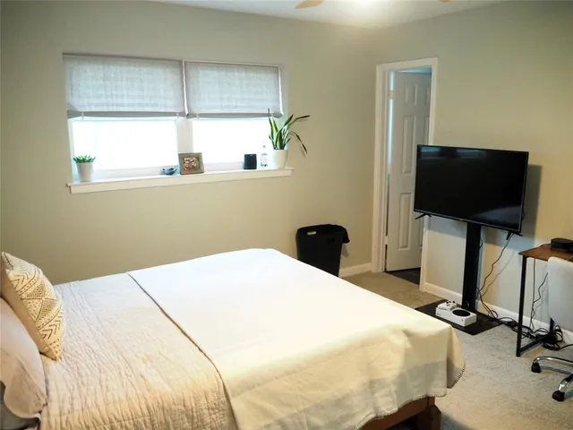 a bedroom with a bed and a flat tv screen on the table