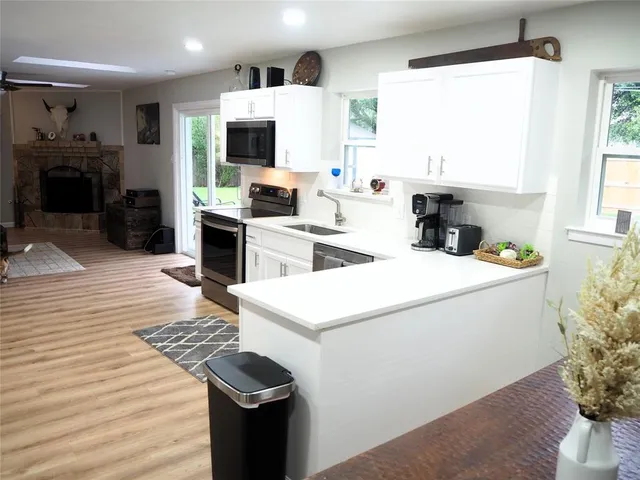 a white kitchen with a sink a microwave and cabinets