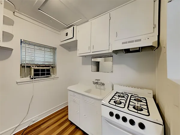 a kitchen with white cabinets and white appliances