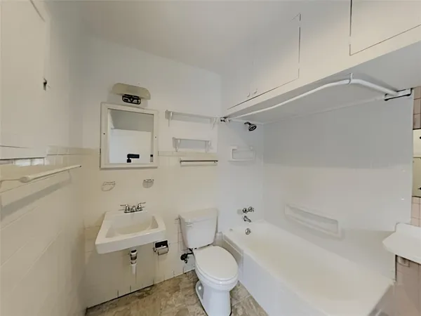 a white toilet sitting next to a bathroom sink and vanity