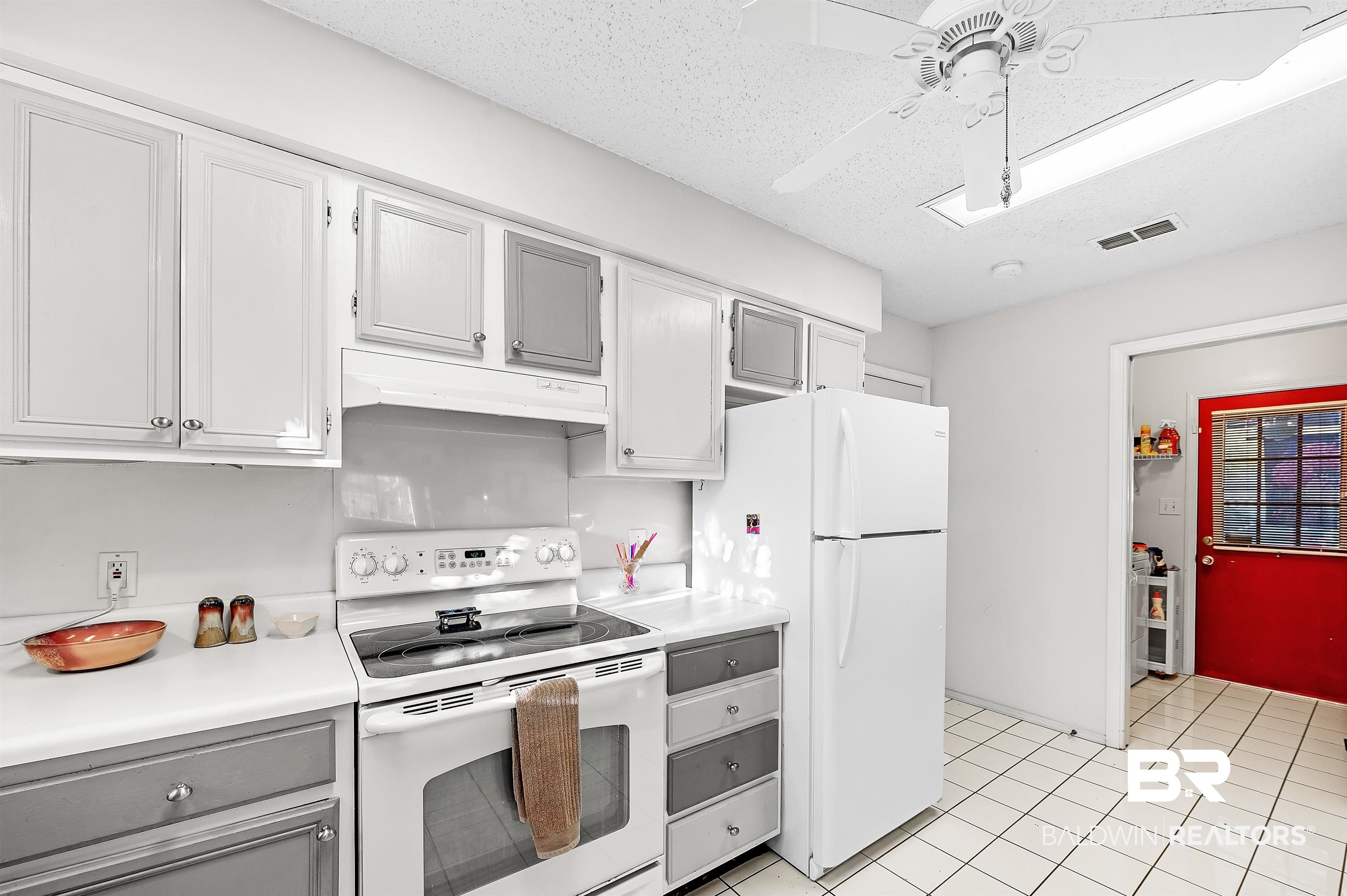 526 Ariel Avenue Foley, AL 36535 - Photo 18 of 33 Kitchen with ceiling fan, white appliances, a textured ceiling, and light tile patterned floors