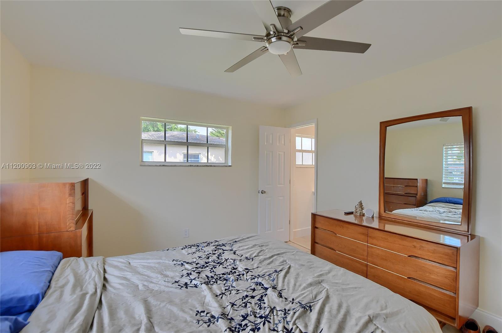 10950 Granite Street Boca Raton, FL 33428 - Photo 12 of 27 a bedroom with a large bed and a mirror