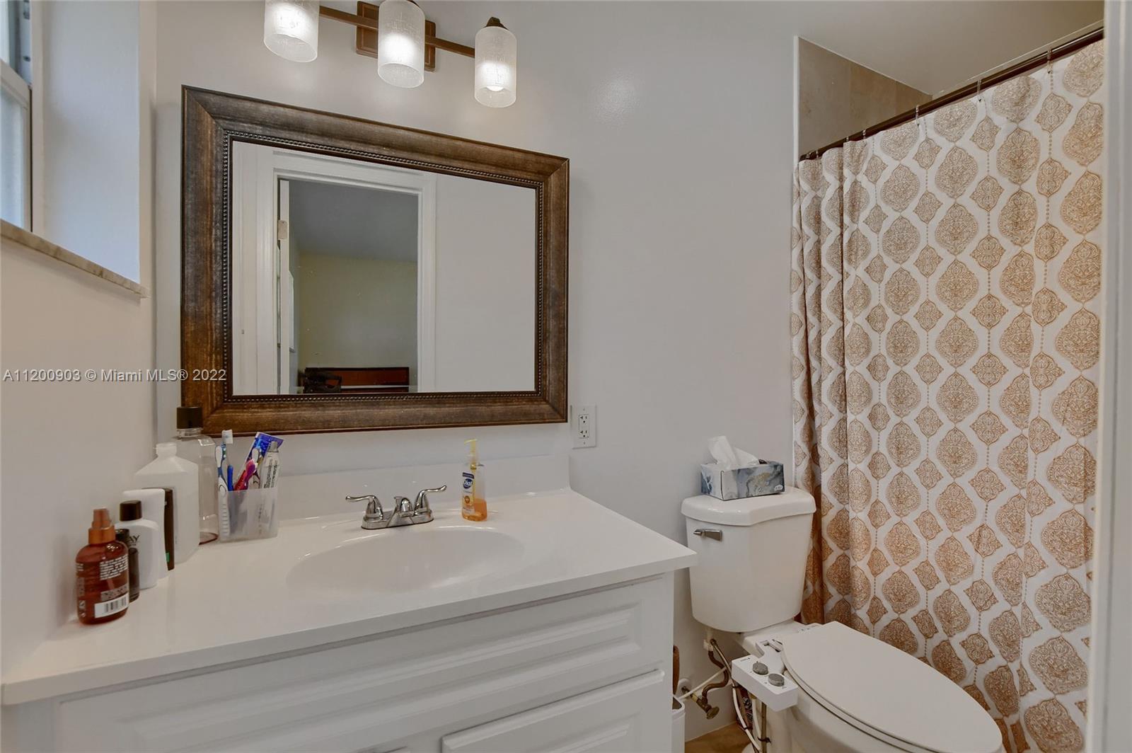 10950 Granite Street Boca Raton, FL 33428 - Photo 14 of 27 a bathroom with a toilet a sink and a mirror