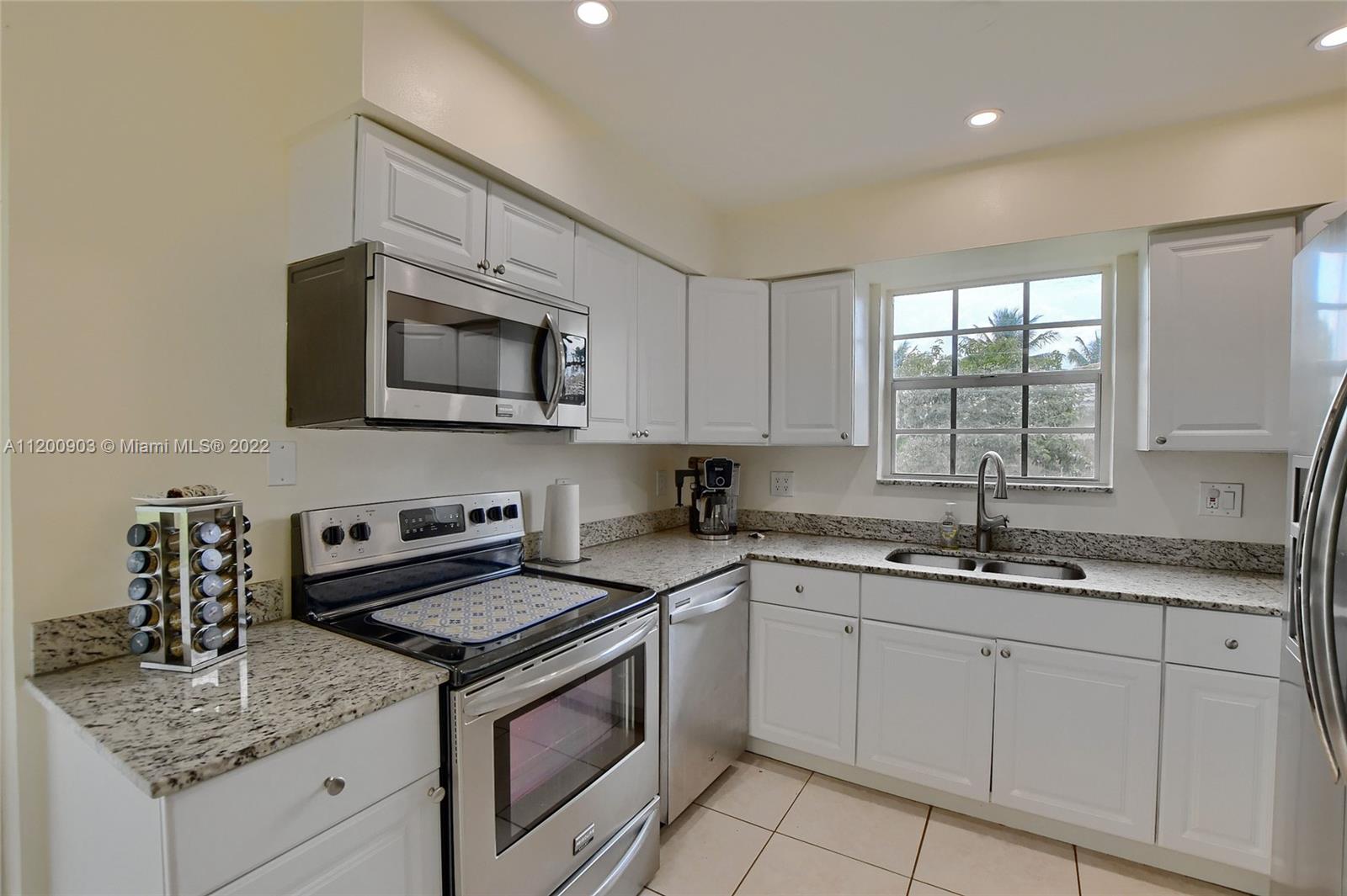 10950 Granite Street Boca Raton, FL 33428 - Photo 3 of 27 a kitchen with stainless steel appliances granite countertop white cabinets granite counter tops and a window