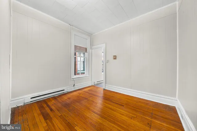 a view of empty room with wooden floor
