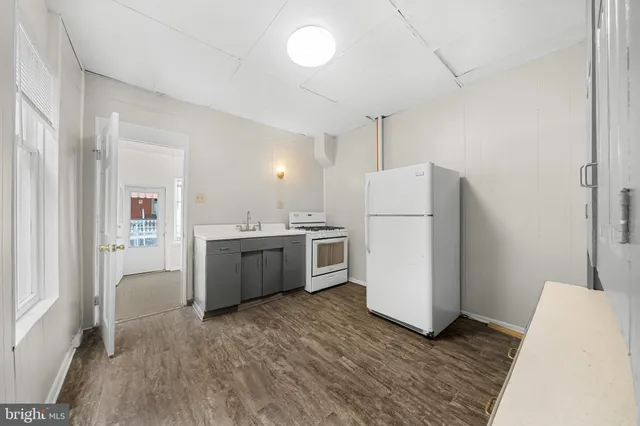 a kitchen with a refrigerator a sink and dishwasher with wooden floor