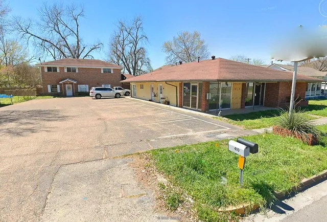 a front view of a house with a yard and potted plants