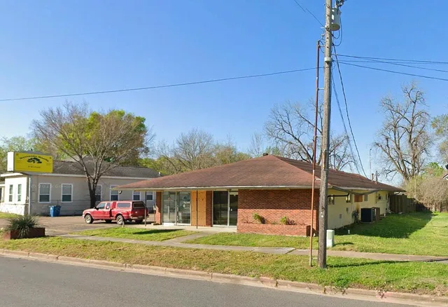 a front view of a house with a yard and trees