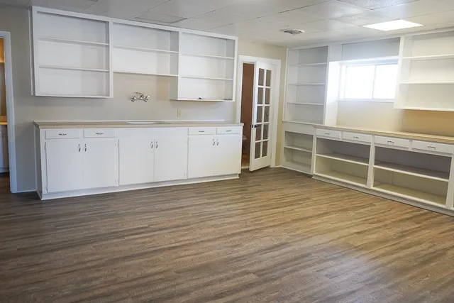 a view of kitchen with wooden floor and cabinets