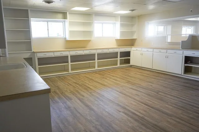 a view of a kitchen with wooden floor and a sink