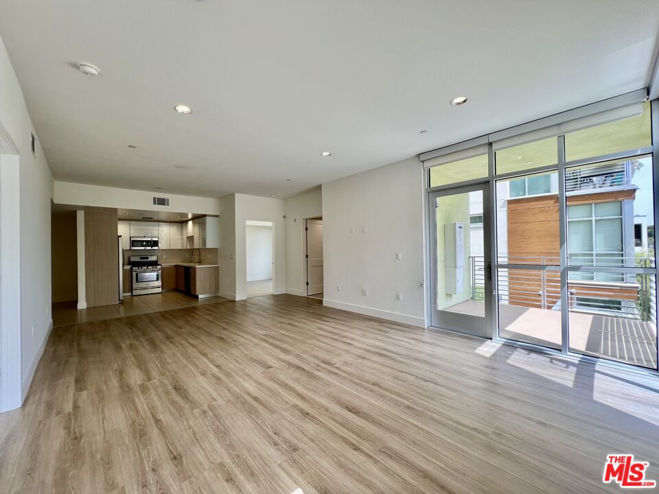 11715 Bellagio Road, Unit 204 Los Angeles, CA 90049 - Photo 7 of 27 a view of empty room with wooden floor and fireplace