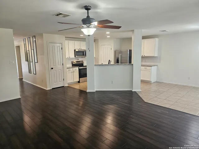 a view of a kitchen with wooden floor and a window