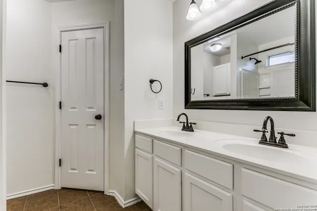a bathroom with a double vanity sink and mirror