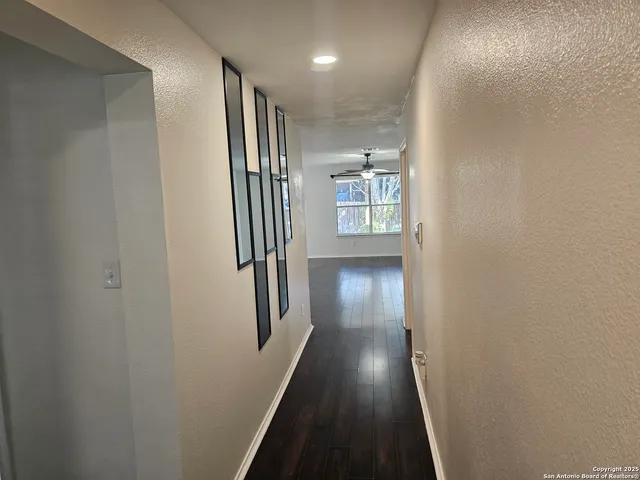 a view of a hallway with wooden floor and staircase
