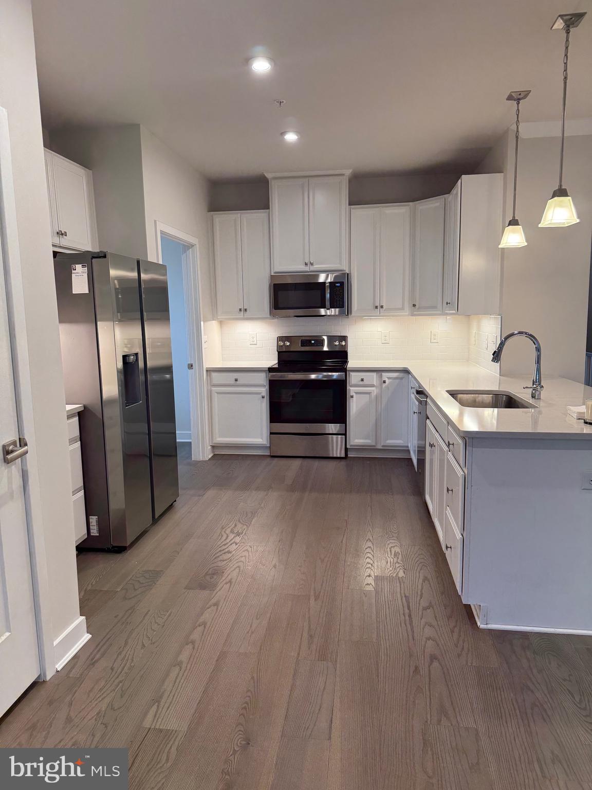 739 Cascade Way Kennett Square, PA 19348 - Photo 38 of 76 a kitchen with stainless steel appliances granite countertop a refrigerator a sink dishwasher a stove and a oven with wooden floor