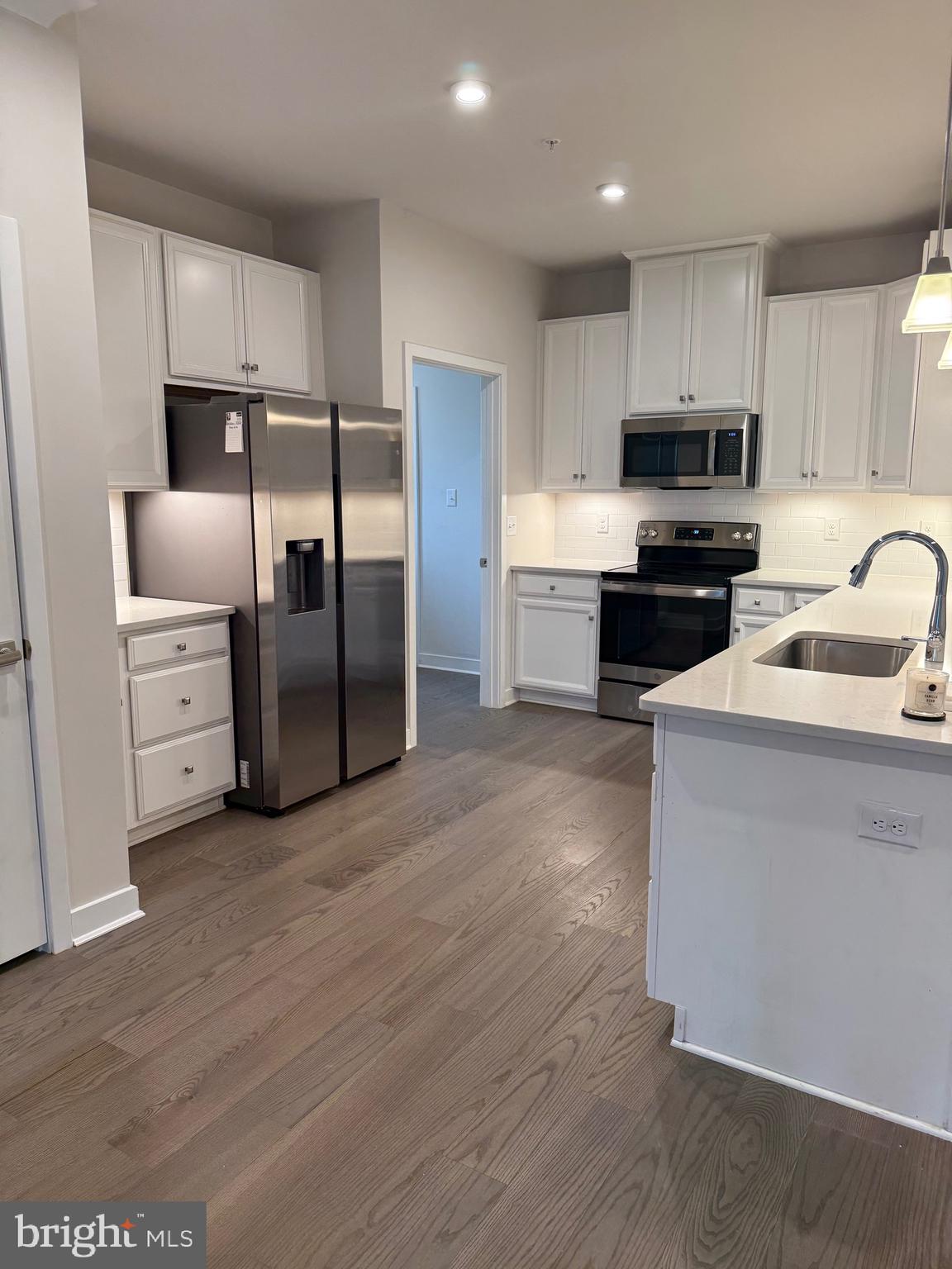 739 Cascade Way Kennett Square, PA 19348 - Photo 40 of 76 a kitchen with granite countertop a refrigerator and a stove top oven