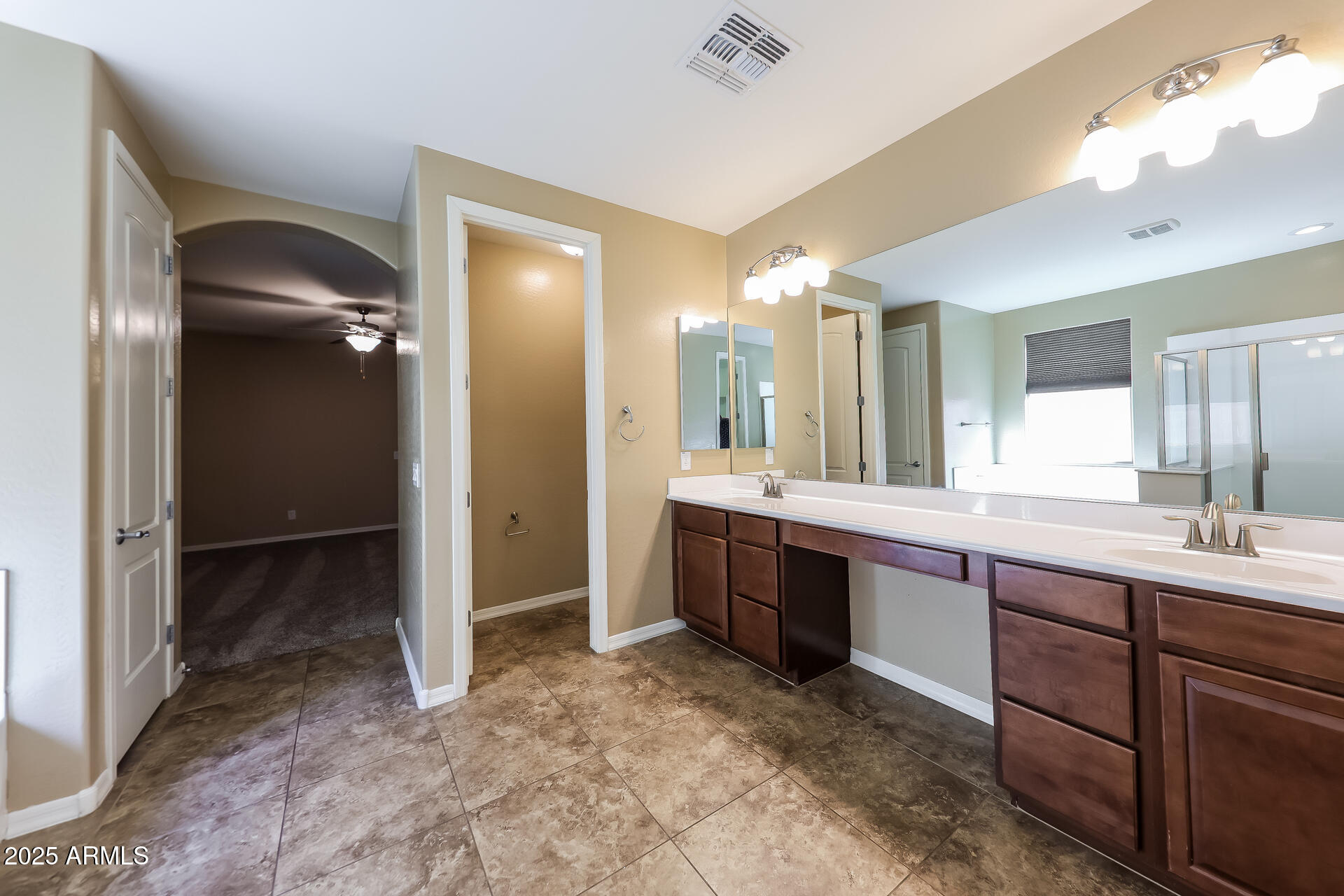 20693 West Ridge Road Buckeye, AZ 85396 - Photo 10 of 16 a large bathroom with a large mirror vanity and shower