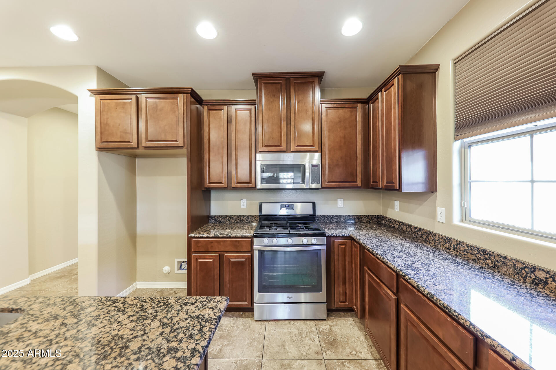 20693 West Ridge Road Buckeye, AZ 85396 - Photo 13 of 16 a kitchen with stainless steel appliances granite countertop a stove a sink and a refrigerator