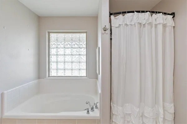 a bathroom with a shower curtain and a window