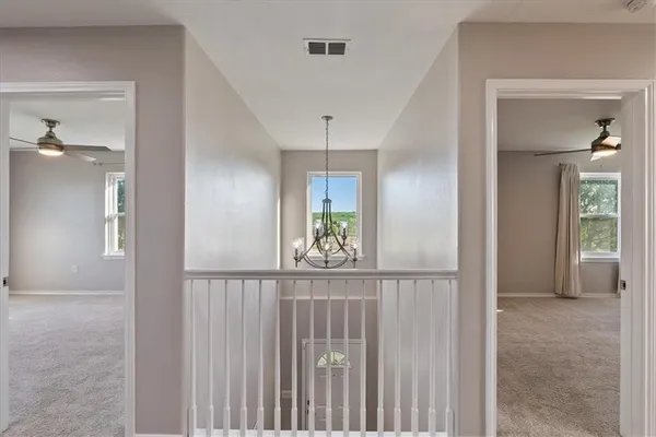 a view of a hallway with windows and stairs