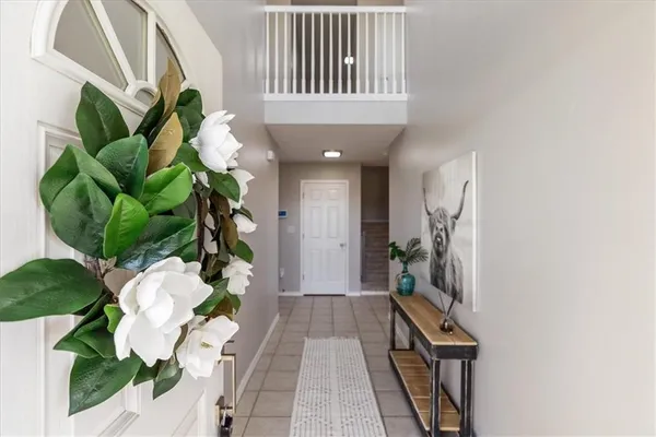 a hallway with painting on the wall and a potted plant