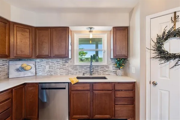 a kitchen with stainless steel appliances granite countertop a sink and a cabinets with wooden floor