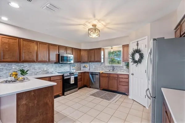 a kitchen with stainless steel appliances granite countertop a sink stove and refrigerator
