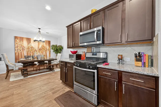 a kitchen with stainless steel appliances granite countertop a stove a sink and a microwave
