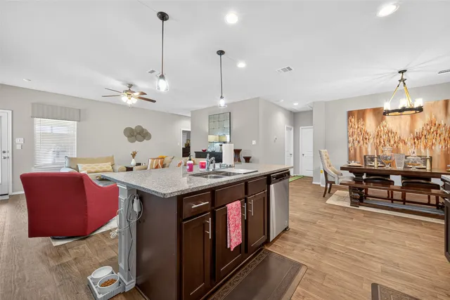 a kitchen that has a lot of cabinets a sink and a wooden floor
