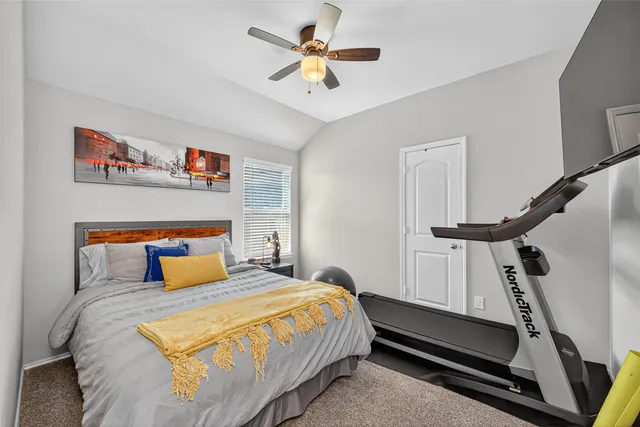 a bedroom with a bed and a ceiling fan